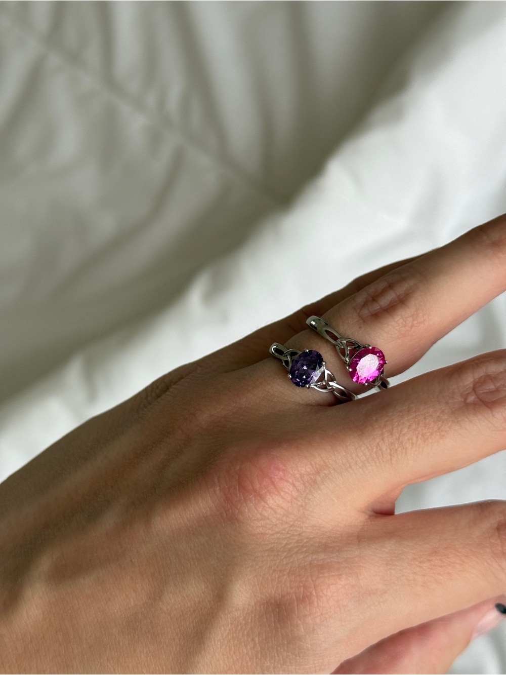 two silver rings with purple and pink gemstones